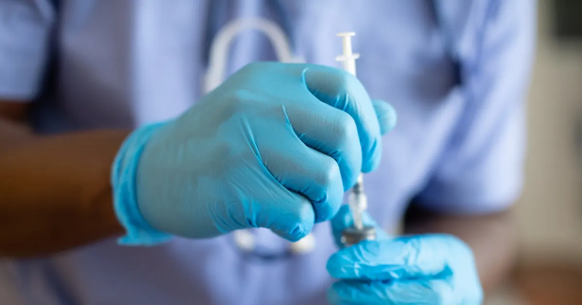 A person holding a medical syringe